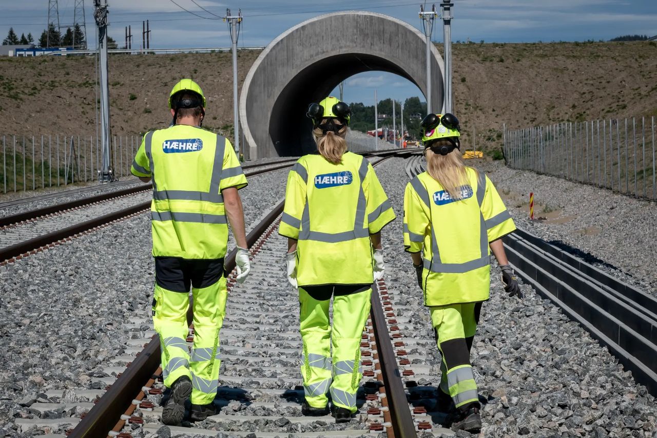 Tre Hæhre-ansatte går langs jernbanespor mot en tunell ved Eidsvoll