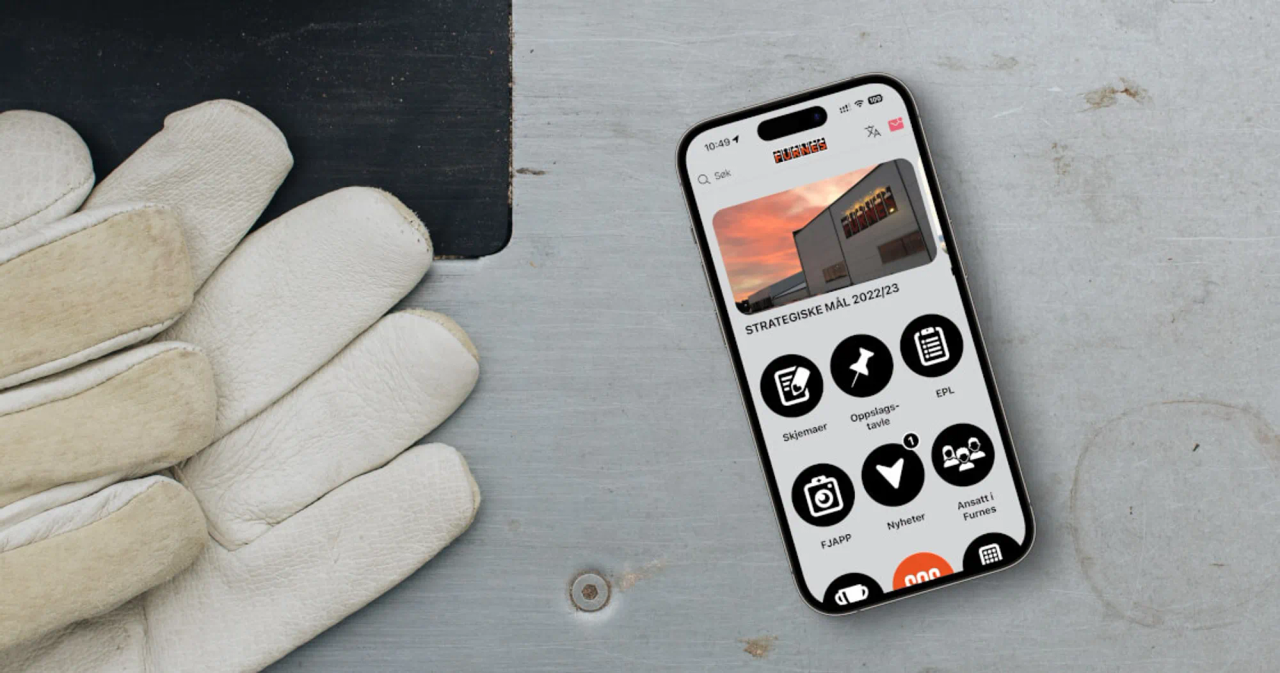En iPhone ligger på en arbeidsbenk med appen til Furnes Jernstøperi åpen